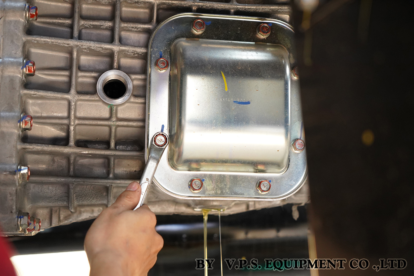 Technician checking gear oil during PTO maintenance service on a truck transmission