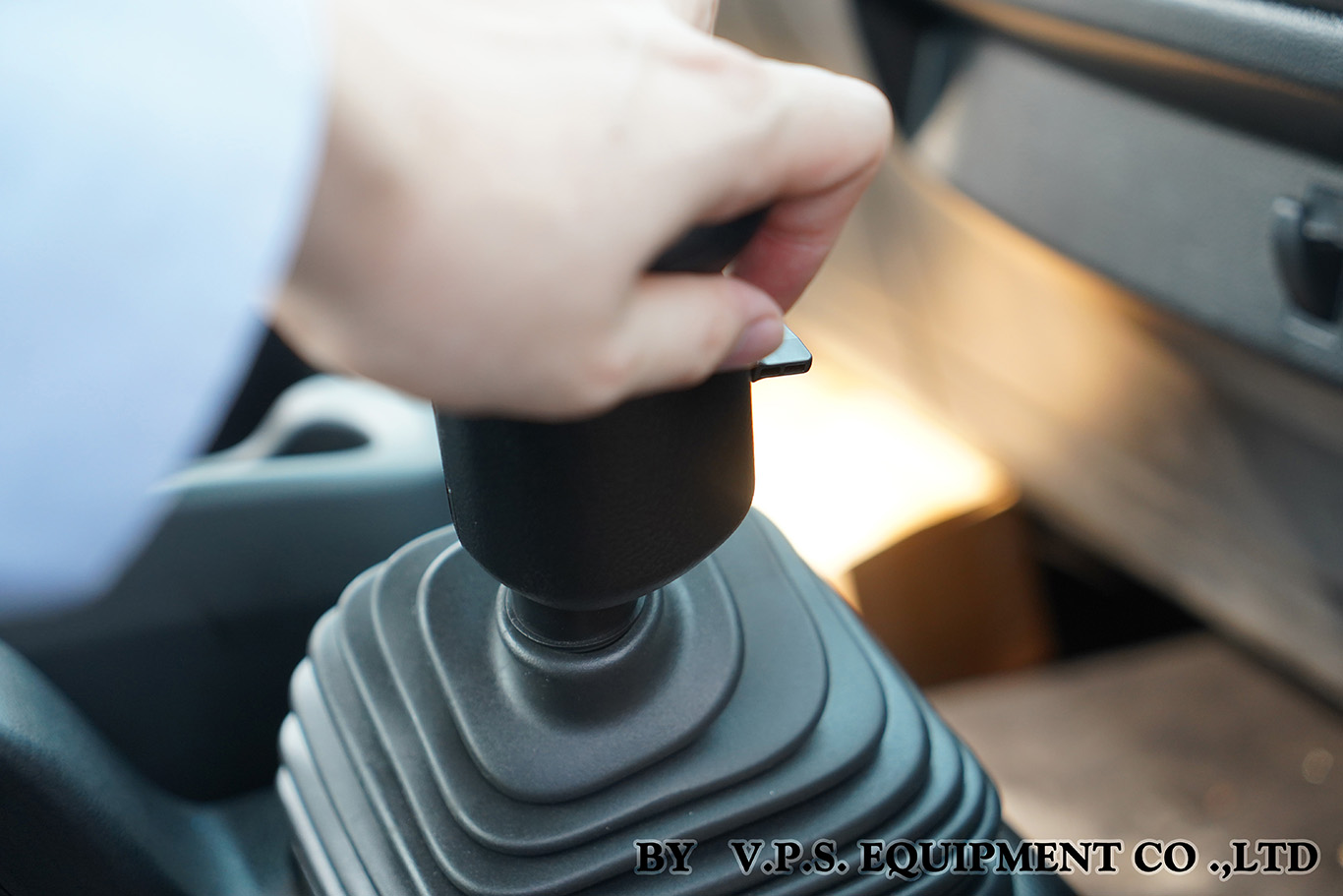 Hand operating a cable-shift PTO lever inside a truck cab